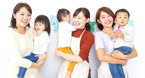笑顔の保育士と子どもたちが並んでいる写真